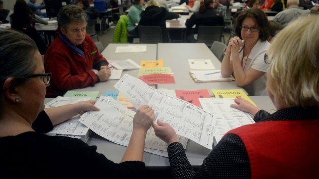 Volunteers and city officials recount presidential ballots in Michigan.