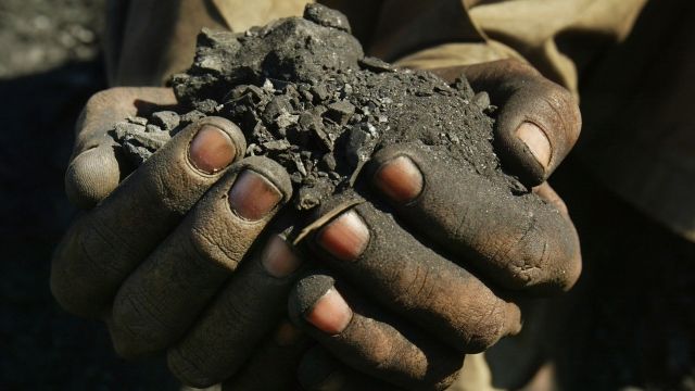 A oal miner holds a handful of coal.