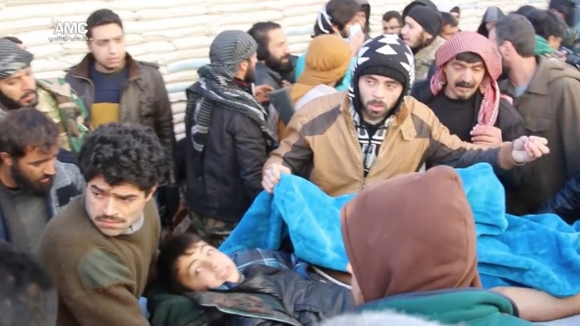 Civilians in Aleppo carry a person during an evacuation.
