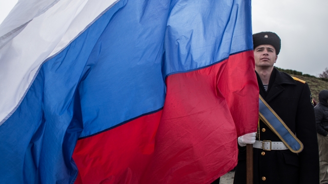 Navy sailor holds Russian flag.