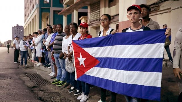 Cubans hold a flag