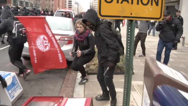 Protesters smash a newspaper box on 13th Street NW in D.C.