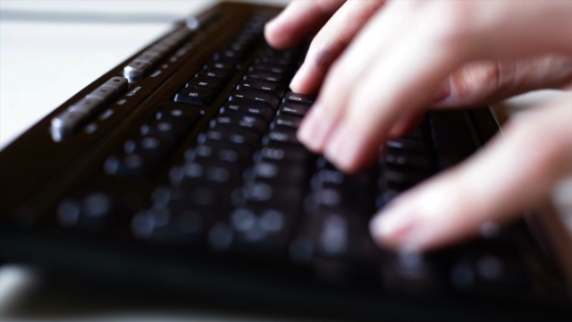 A person types at a keyboard