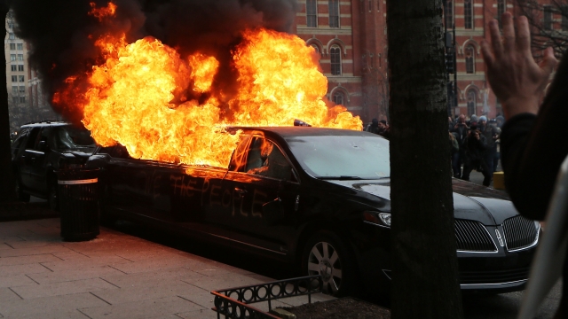 A limousine burns after being smashed by anti-Trump protesters.