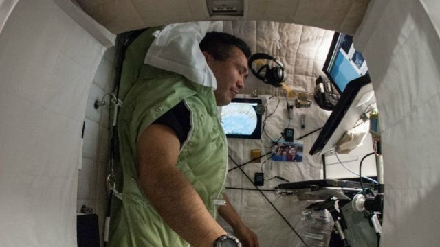 An astronaut sleeps on the International Space Station.