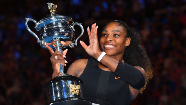 Serena Williams waves while holding the trophy after her Australian Open win.