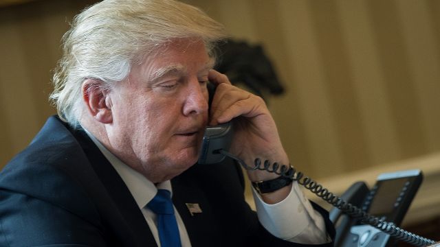 President Donald Trump speaks on the phone in the Oval Office of the White House.