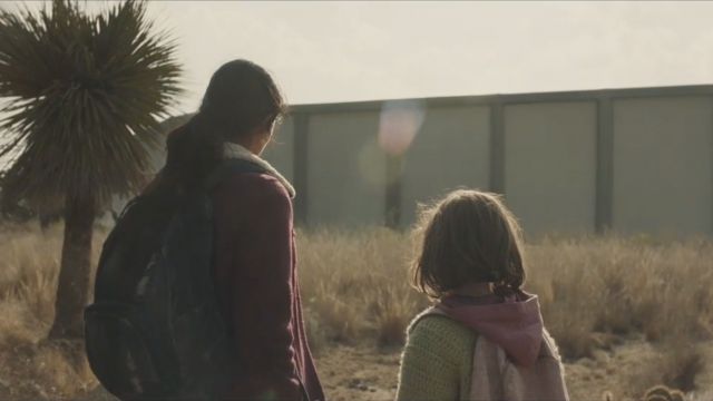 A mother and daughter see a border wall blocking their paths