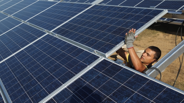 A worker installs solar panels.