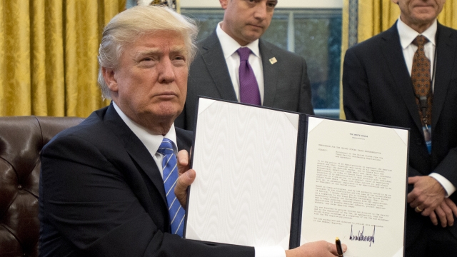 President Donald Trump shows an Executive Order.