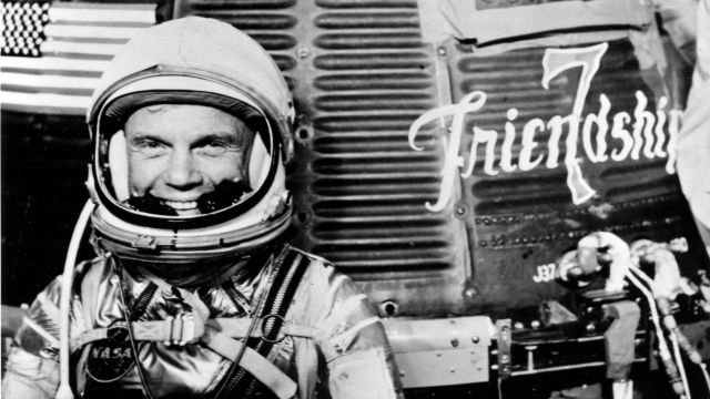 Astronaut John Glenn in front of the Friendship 7 spacecraft