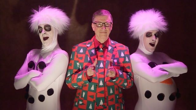 Bill Gates stands between people in snowman costumes.