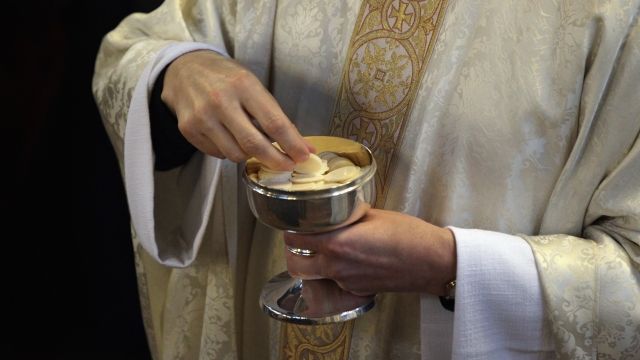 A priest distributes Holy Communion during a Catholic mass.