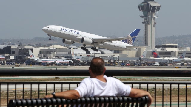 A United Airlines jet takes off near an air traffic control tower at LAX.