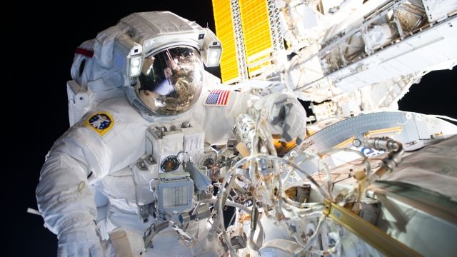 Astronaut conducting spacewalk outside of the International Space Station