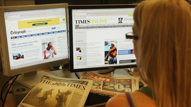 Computer monitors display two newspaper websites