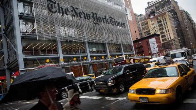 People walk past The New York Times building