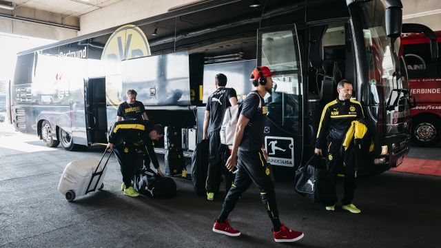 Players next to Borussia Dortmund's team bus.