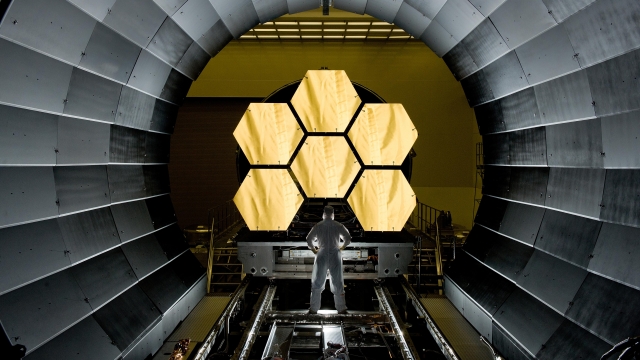Engineer stands in front of James Webb telescope's first few mirrors