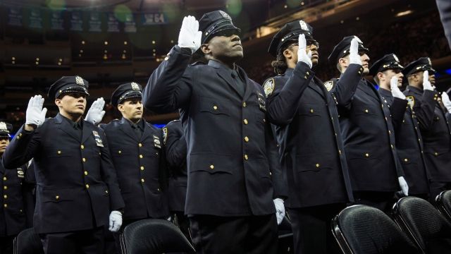 Police officers recite an oath during a New York Police Department graduation in 2014.