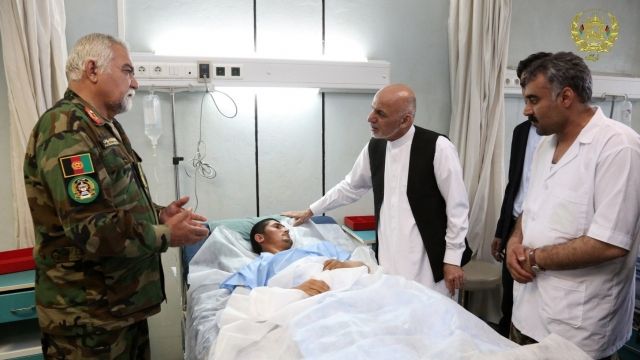 Afghan President Ashraf Ghani visits an injured soldier.