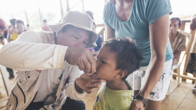 A child is given a dose of antibitoics to prevent trachoma.