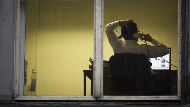 A city office employee works into the night as darkness closes in.
