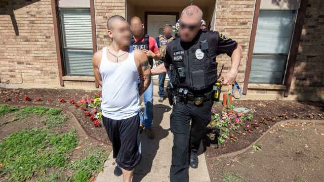 ICE officials arrest a man.
