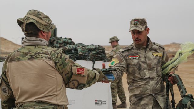 U.S. Army member gives supplies to Iraqi military