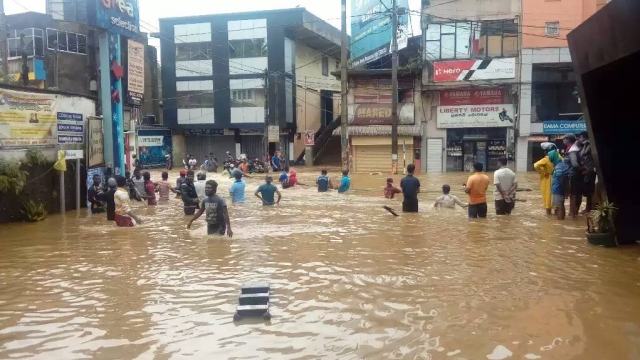 Sri Lanka residents wade through high flood waters.