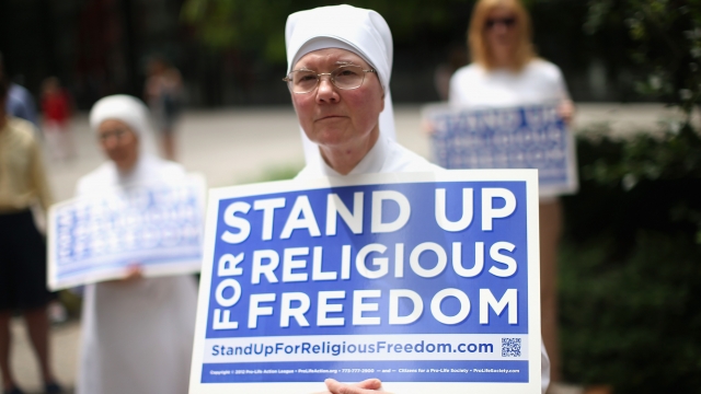 A nun holds a sign advocating for religious freedom