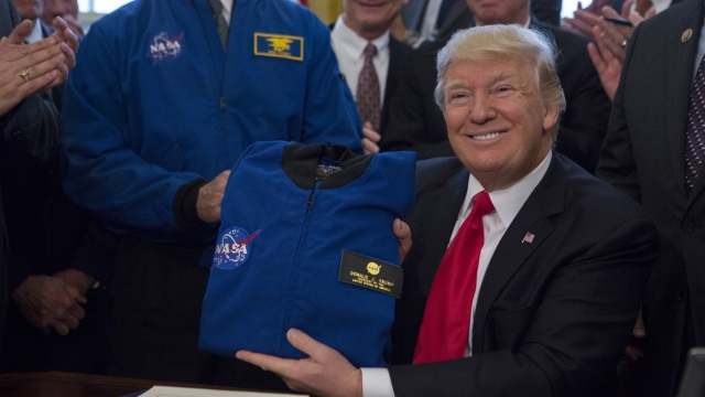 President Trump holding a NASA flight jacket