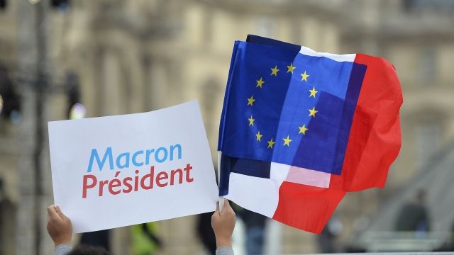 Macron supporter waves flags at his election victory celebration