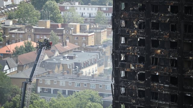 Firefighters examine Grenfell Tower after the fire