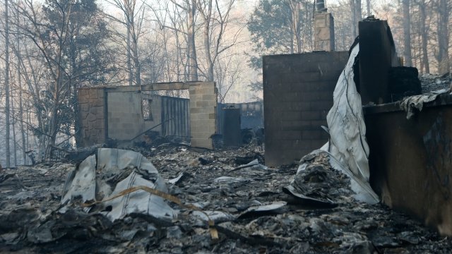 The remains of a home smolders after a wildfire in Gatlinburg, Tennessee.