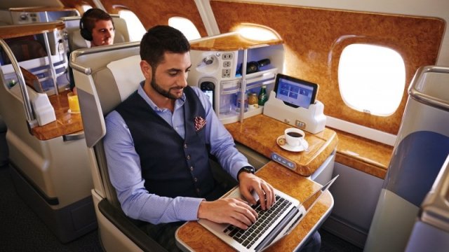 A man works on his laptop during an Emirates flight.