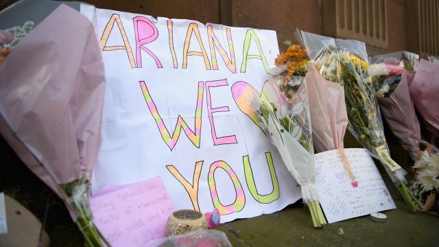 A sign sits among flowers after Manchester bombing