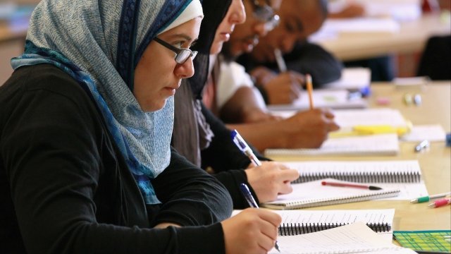 Muslim student takes notes during lecture