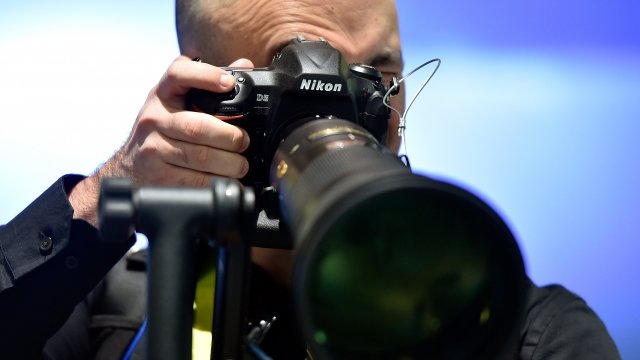 A man shoots photos on a Nikon D5 DSLR camera