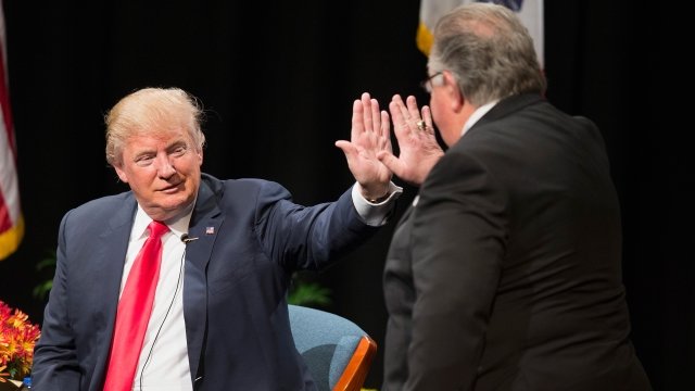 President Trump high-fives his campaign co-chair Sam Clovis