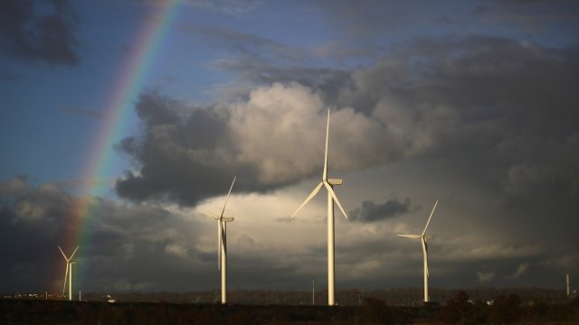 A rainbow appears in front of wind turbines in England