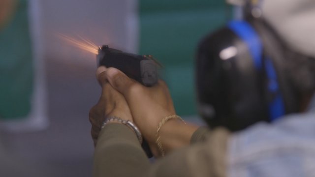 A woman from the Chicago-area gun club Ladies of Steel fires a handgun.