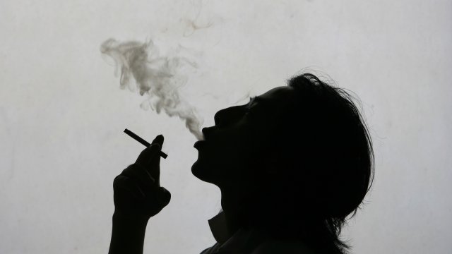 A man exhales smoke while smoking a cigarette.