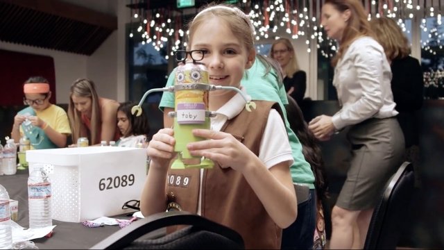 Girl Scout poses with her homemade robot