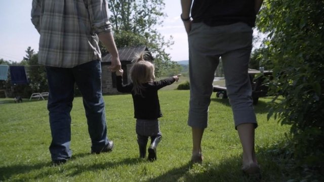 A child who was born intersex walks with her parents