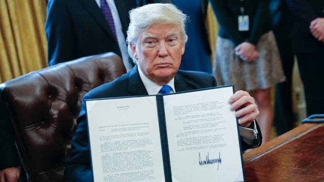 President Donald Trump holds an executive order he signed