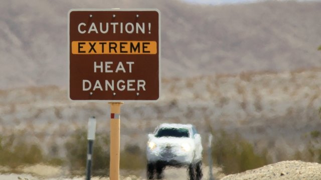 Heat waves rise near a heat danger warning sign at Death Valley National Park.
