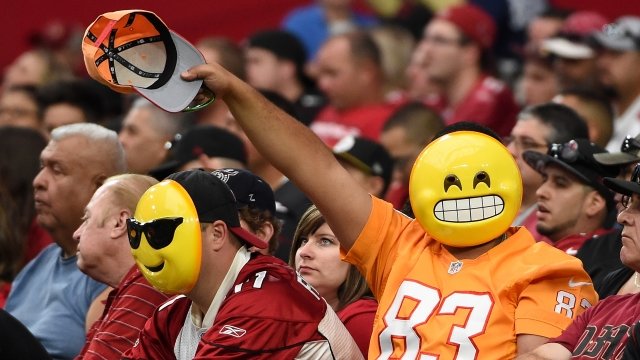 Fans at an NFL game strike a pose for the camera