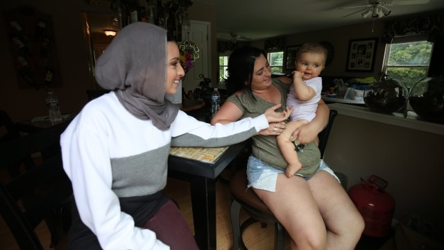 Noor Tagouri sits with Taylor Smith, who is a former heroin user, and Smith's daughter
