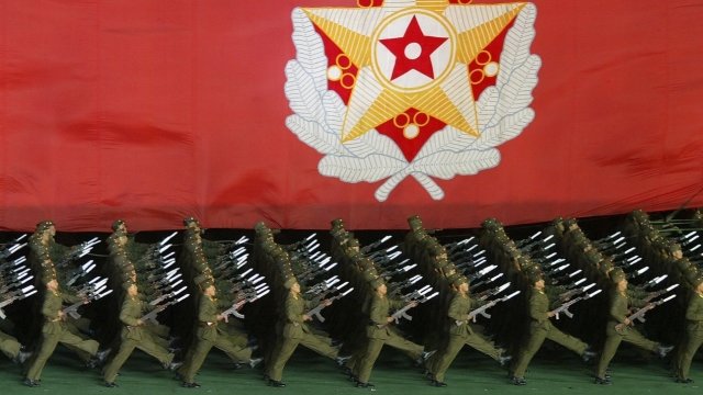 North Korean military cadets hold a flag during a performance.